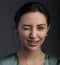 Portrait of playful and sweet young woman showing tongue giving wink, dressed in a green blouse isolated dark gray background,