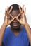 Portrait of playful young man with hands over eyes against white background