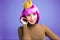 Portrait playful young woman with cut purple hair, gold crown, luxury dress having fun on violet background. Great