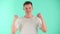 Portrait of a pleasantly excited young European guy in studio. A young man with a beautiful smile in a white T-shirt on