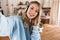 Portrait of pleased blond girl 20s wearing headphones smiling and taking selfie photo at home