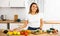 Portrait of pleased housewife preparing salad in kitchen