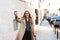 Portrait of pleased woman drinking takeaway coffee while walking through city street