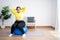 Portrait plus size woman doing exercise with fitness ball in home gym. Overweight woman sitting on a pilates ball and Stretching