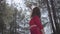 Portrait portrait graceful womans body in red dress in the forest. Lady raises hand in the sky