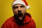 Portrait Portrait of a mad modern santa claus. She screams, rejoices, gets angry. Close up. Isolate on a yellow background.of an