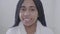 Portrait of positive African American woman with dreadlocks looking at camera and smiling. Pretty teenager in white