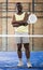 Portrait of positive afro american man with padel racket