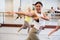 Portrait of a positive Asian woman enjoying energetic dancing in a studio