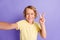Portrait of positive boy take selfie photo make v-sign wear yellow t-shirt isolated over violet color background
