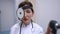 Portrait of positive Caucasian female otolaryngologist posing in slow motion with medical equipment. Beautiful woman