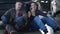 Portrait of positive Caucasian man and woman leaning on car and talking. Smiling male and female maintenance engineers