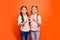 Portrait of positive cheerful two kids girl stand together make heart fingers sign of friendly loving family sister