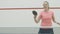 Portrait of positive confident Caucasian sportswoman playing ping-pong in gym. Smiling young blond Caucasian woman