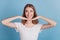 Portrait of positive curious girl palms chin look side empty space white smile on blue background