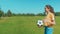 Portrait of positive cute adolescent girl juggling soccer ball in nature
