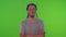 Portrait of a positive dark-skinned young man showing ok on a green screen