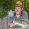 Portrait of positive elderly man bee-keeper wearing straw hat