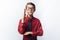 Portrait of a positive and emotional schoolboy, pulls his hand to the Board, white background, glasses, red shirt, business theme,