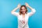 Portrait of positive good-natured woman making bunny ears gesture and smiling. isolated on blue background