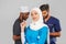 Portrait of positive healthcare workers standing in the hallway and looking at the camera. Group of paramedics smiling over gray