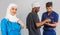 Portrait of positive healthcare workers standing in the hallway and looking at the camera. Group of paramedics smiling over gray