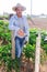 Portrait of positive hired worker on farm field on day