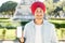 Portrait of positive Indian ethnic guy in casual shirt and national sikh turban showing smartphone with empty screen in