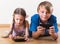 Portrait of positive kids playing with smartphones