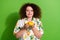 Portrait of positive lovely girl closed eyes arms hold smell fresh juicy lemons  on green color background