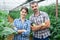 Portrait of positive married couple in greenhouse