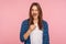 Portrait of positive playful girl in checkered shirt holding fake curled mustache on stick and winking