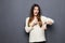 Portrait of positive pretty young woman pointing at clock