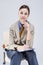 Portrait of Positive and Smiling Gleeful Woman in Blue Shirt and Tie. Making Notes with Notepad While Sitting in Chair