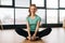 Portrait of positive sporty young woman practicing yoga, sitting in butterfly konasana pose, stretching legs muscles on