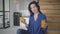 Portrait of positive successful caucasian woman holding orange and glass with juice and smiling at camera. Happy