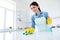 Portrait of positive woman professional worker wear latex gloves disinfect table surface hold bottle sprayer wash rag in