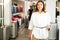 Portrait of a positive young girl in a shop with a travel suitcase