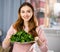 Portrait of a positive young woman with a plate of spinach