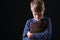 Portrait of praying boy with Bible on dark background