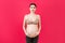 Portrait of pregnancy belt dressed on suffering pregnant woman for reducing pain in the back at pink background with copy space.