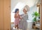 Portrait of pregnant woman with small daughter indoors in bathroom at home, brushing hair.