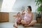 Portrait of pregnant woman with small daughter indoors in bathroom at home, brushing teeth.