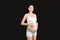 Portrait of pregnant woman wearing elastic bandage against pain in the back at black background with copy space. Orthopedic