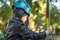 Portrait of preschooler boy in a protective helmet and ammunition. Kid enjoys climbing in the ropes course adventure.