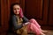 Portrait of a pretty adorable child girl, little baker confectioner in chef apron and kitchen mittens, smiling to camera