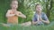 Portrait pretty adorable little girl and the handsome boy sitting on the grass meditating. Children are in yoga. The