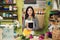 Portrait of pretty Asian florist with tablet computer in hands