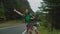 Portrait of pretty asian woman hiker with backpack hitchhiking on mountain road