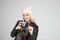 Portrait of pretty blond hair smileing young teenage hipster woman model with retro photo camera wearing a pink hat